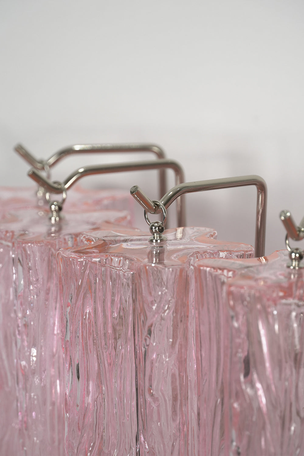 Cascading Prism Pink Glass Wall Light | Glass, Metal | Close-up focus on the silver-finished metal hardware and suspension system | Detail shot | vexa lamps Cascading Prism