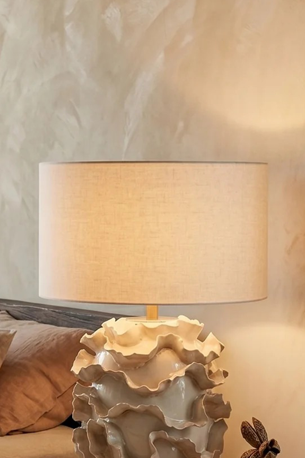 Coralia Ruffled Ceramic Table Lamp with neutral drum shade in a contemporary interior setting.
