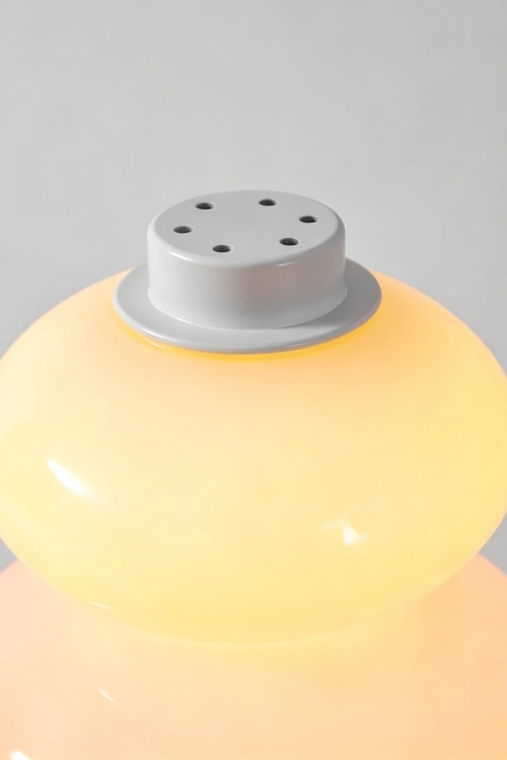 Dolce Stacked Pastel Glass Table Lamp | Glass, Metal | Top-down macro view of the pastel yellow top tier and the white matte cap with ventilation holes | Detail shot | vexa lamps
