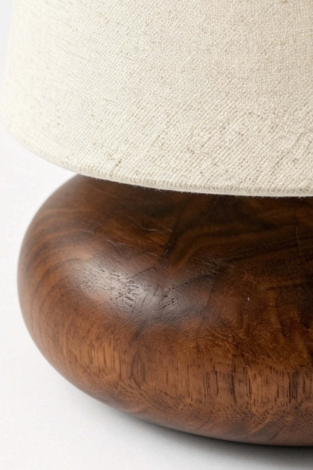 Sylvan Oval Walnut Table Lamp | Wood, Fabric, Metal | Macro view emphasizing the organic texture of the beige fabric and the rich grain of the walnut base | Detail shot | vexa lamps Sylvan Oval