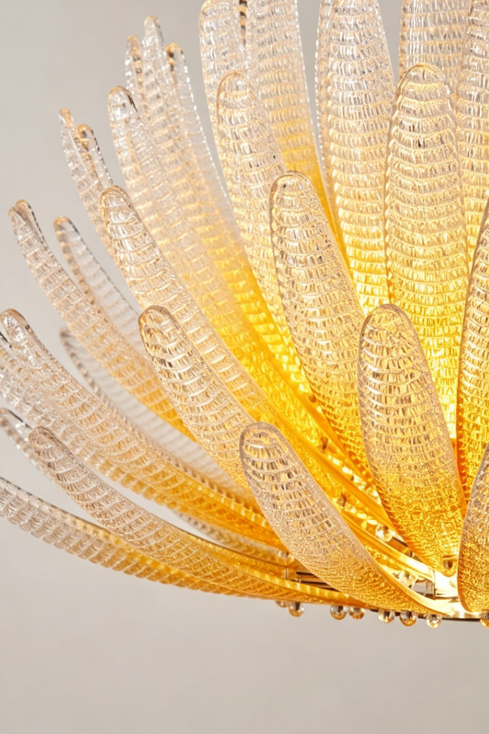 Helios Agave Glass Starburst Chandelier | Glass, Metal | Close-up focus on the spiky, upward-reaching textured glass petals with a golden glow | Detail shot | vexa lamps Helios Agave