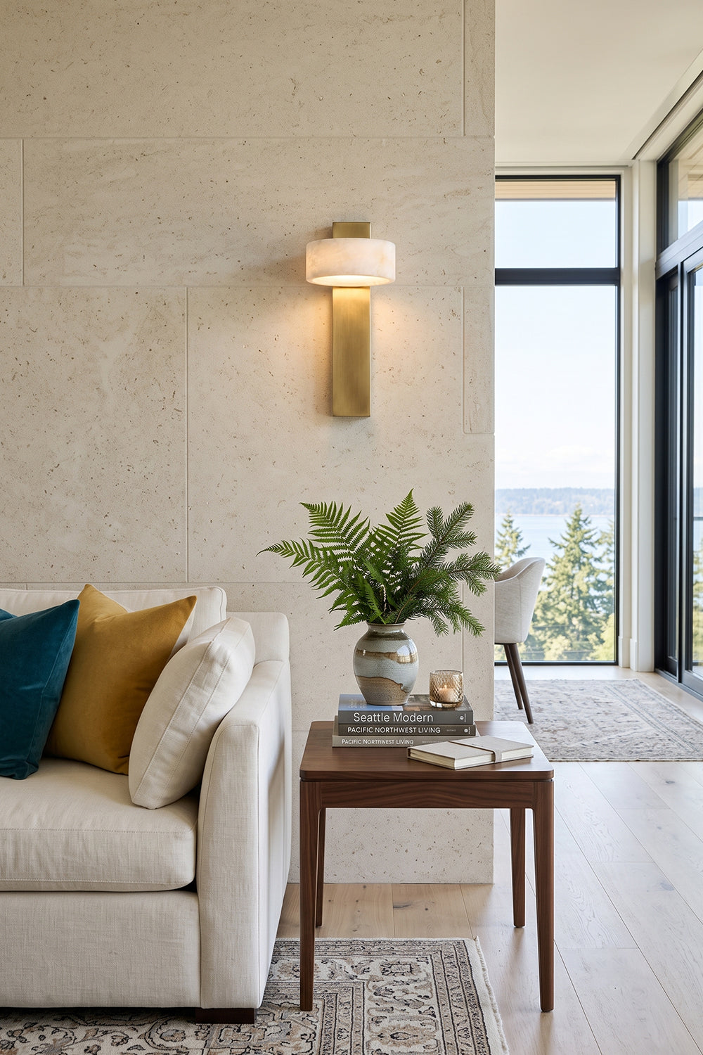 Alaric Alabaster Bar Wall Sconce | Natural Alabaster and Brass | Styled on a textured stone wall behind a cream sofa and a wooden console table with a green plant | vexa lamps