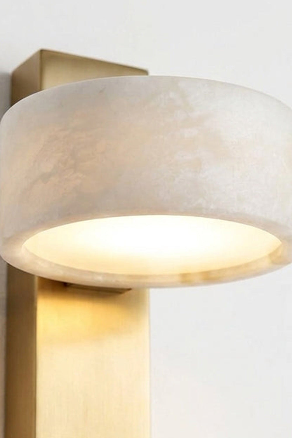 Alaric Alabaster Bar Wall Sconce | Natural Alabaster and Brass | Close-up front view of the glowing translucent cylindrical stone shade highlighting its organic veining | vexa lamps