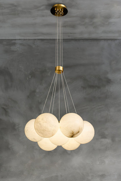 Amandine Alabaster Globe Cluster Pendant Light hanging in a modern dining room with a stylish gray background.