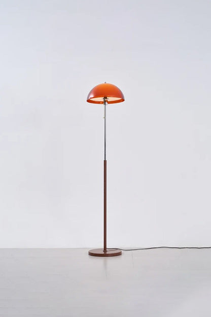 Ambrose Amber Dome Floor Lamp | Amber Glass, Metal and Wood | Full standing view glowing in a studio setting with soft backdrop | vexa lamps