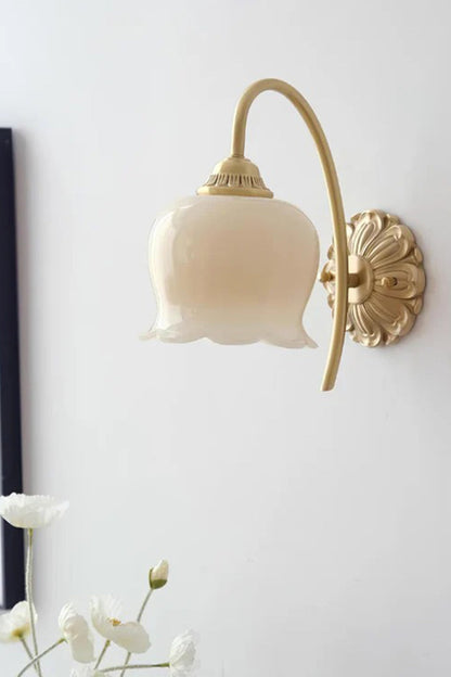 Amelie Vintage Tulip Wall Lamp with frosted glass shade and antique brass backplate illuminating a floral-inspired interior.