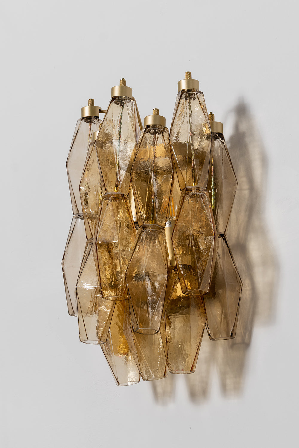 Unlit amber polyhedral glass sconce with metal hooks | Metal, Glass | Side perspective product shot | vexa lamps