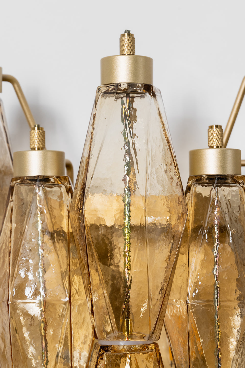 Close-up of metal hardware and amber glass prisms | Metal, Glass | Top detail showing the brass-finish hangers | vexa lamps