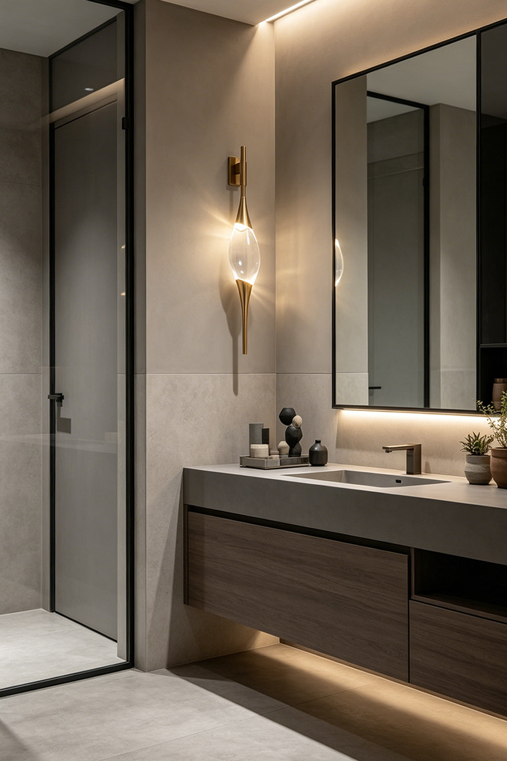Astraea Crystal Linear Wall Sconce | Crystal, Brass | Mounted beside a mirror in a sleek modern minimalist bathroom vanity area, casting a warm elegant glow | vexa lamps