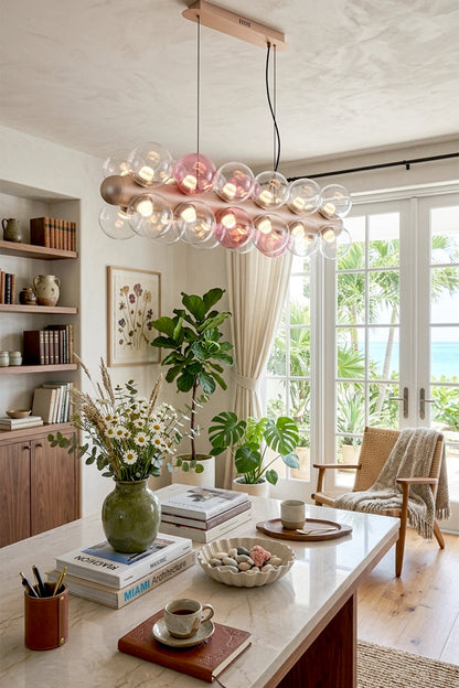 Astraea Linear Prismatic Globe Chandelier in modern dining room with plants and ocean view.