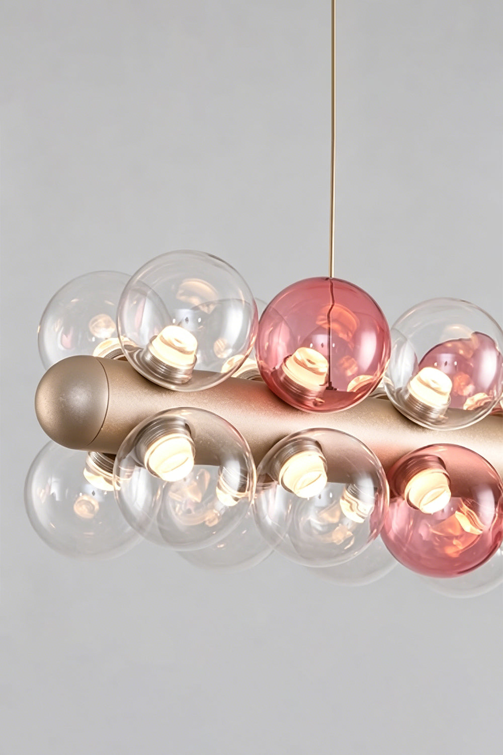 Astraea Linear Prismatic Globe Chandelier featuring hand-blown glass spheres and a brushed champagne-gold finish.