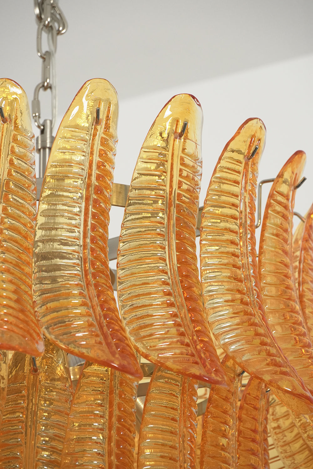 Aurelia Helix Amber Glass Cascade Chandelier featuring hand-poured amber glass plumes in a spiral design.