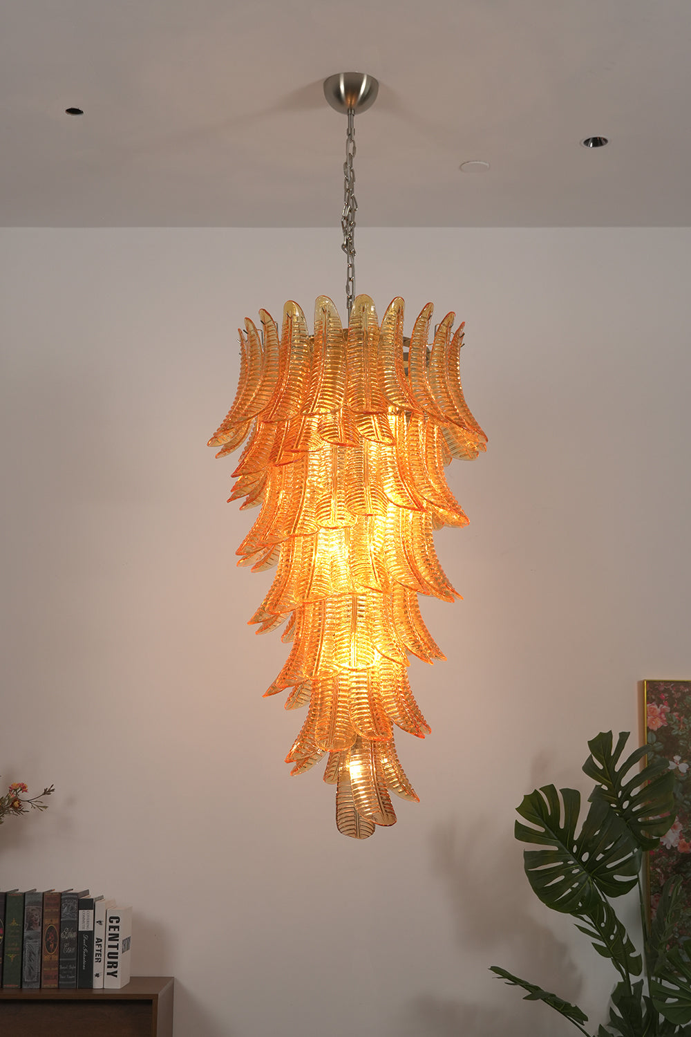 Aurelia Helix Amber Glass Cascade Chandelier illuminating a room with warm amber tones.