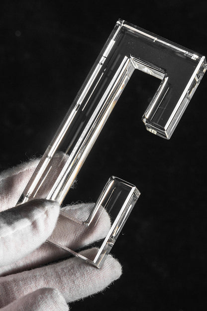 Aven Tiered Glass Prism Chandelier | Glass, Metal | A gloved hand holding a single clear molded rectangular glass link prism hook to showcase size and texture | Detail shot | vexa lamps