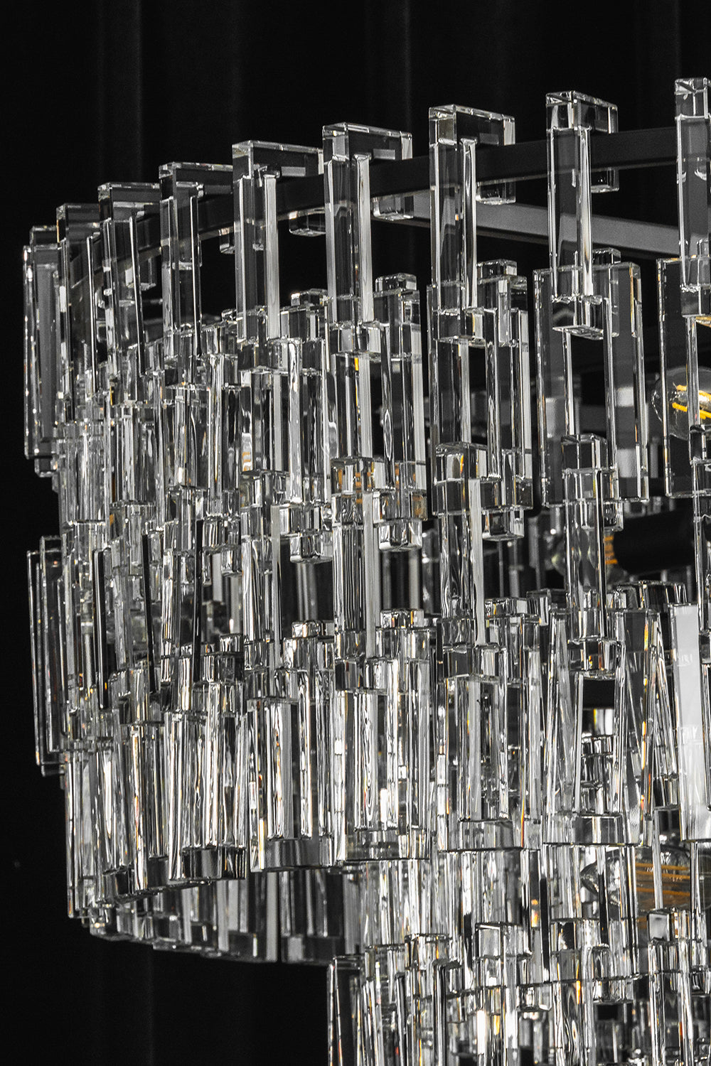 Aven Tiered Glass Prism Chandelier | Glass, Metal | Profile studio close-up of the unlit crystal chandelier highlighting the sparkle of clear glass against a dark background | vexa lamps
