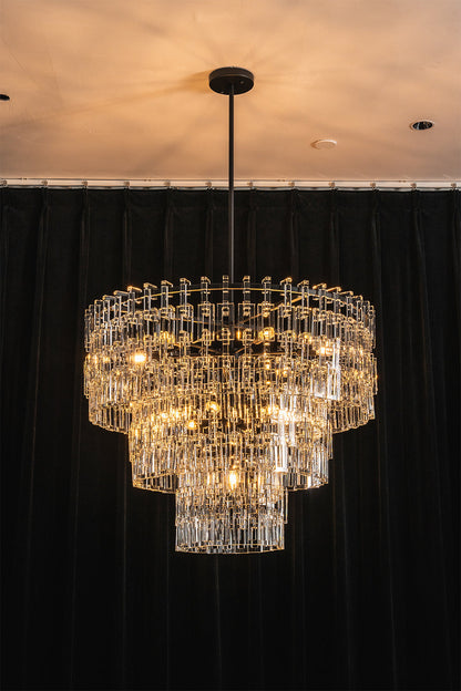 Aven Tiered Glass Prism Chandelier | Glass, Metal | Centered view of the fully illuminated black tier variant casting warm ambient light against a solid dark backdrop | vexa lamps
