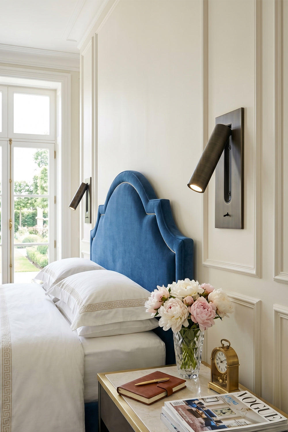 Axial Pivot Folding LED Wall Lamp illuminating a stylish blue upholstered headboard in a chic bedroom setting.