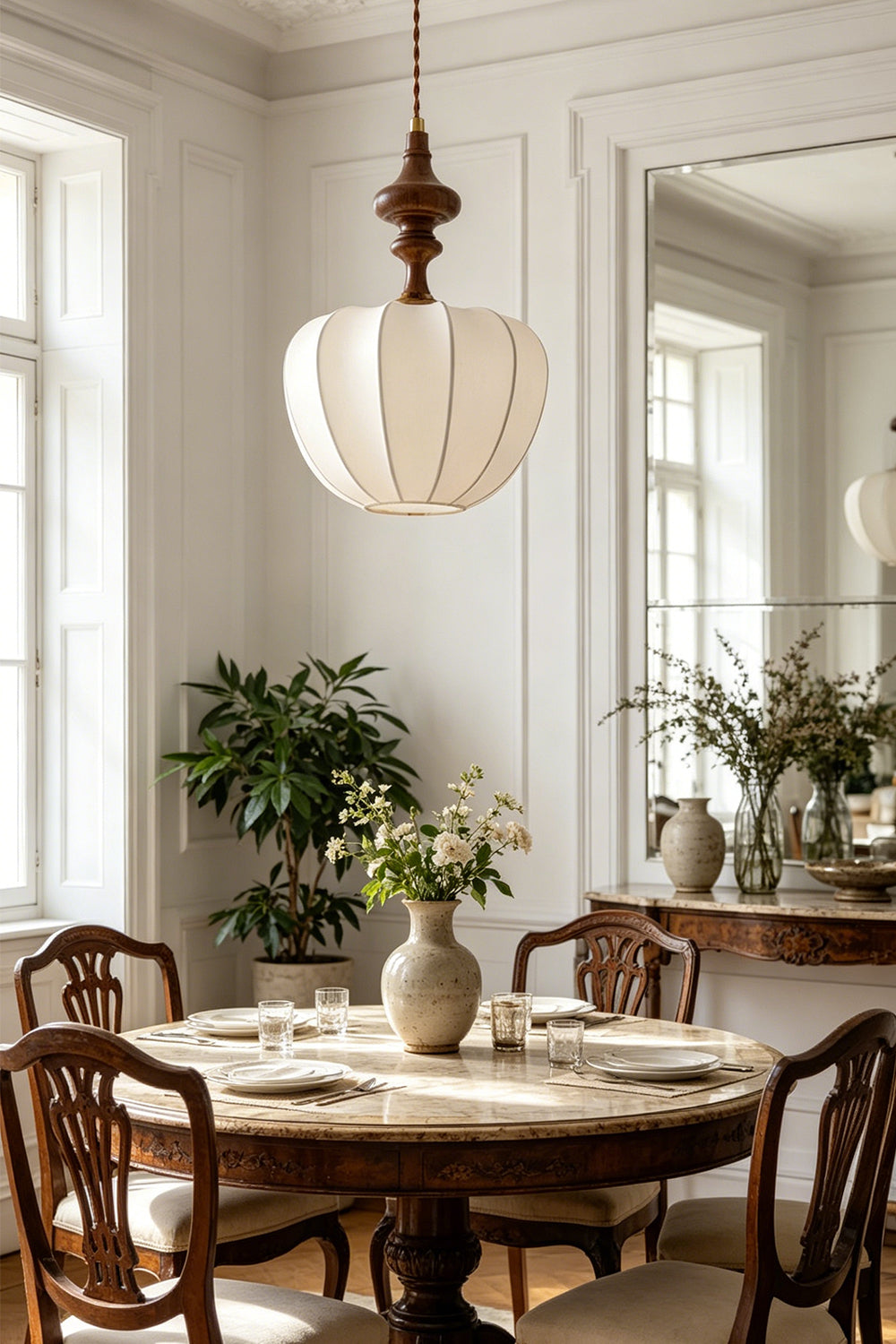 Baird Mid-Century Silk Pendant Light hanging over a dining table with elegant decor and natural light.