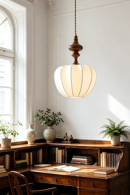 Baird Mid-Century Silk Pendant Light hanging above a wooden desk in a bright room with plants and books.