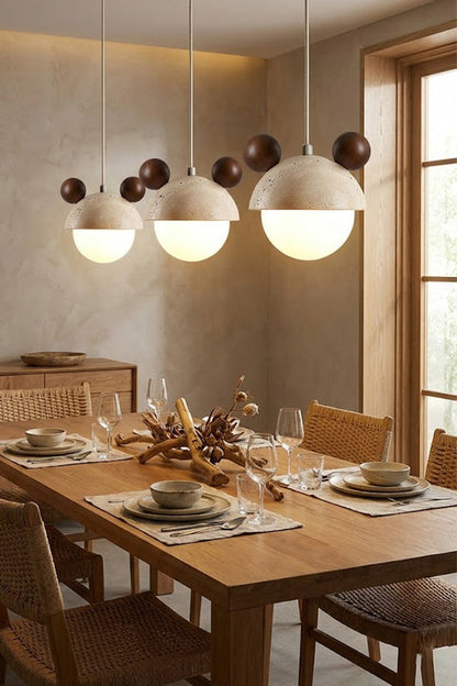 Trio of bear ear travertine pendants over a dining table | Travertine, Metal, Glass | Installed in a row in a modern dining room | vexa lamps