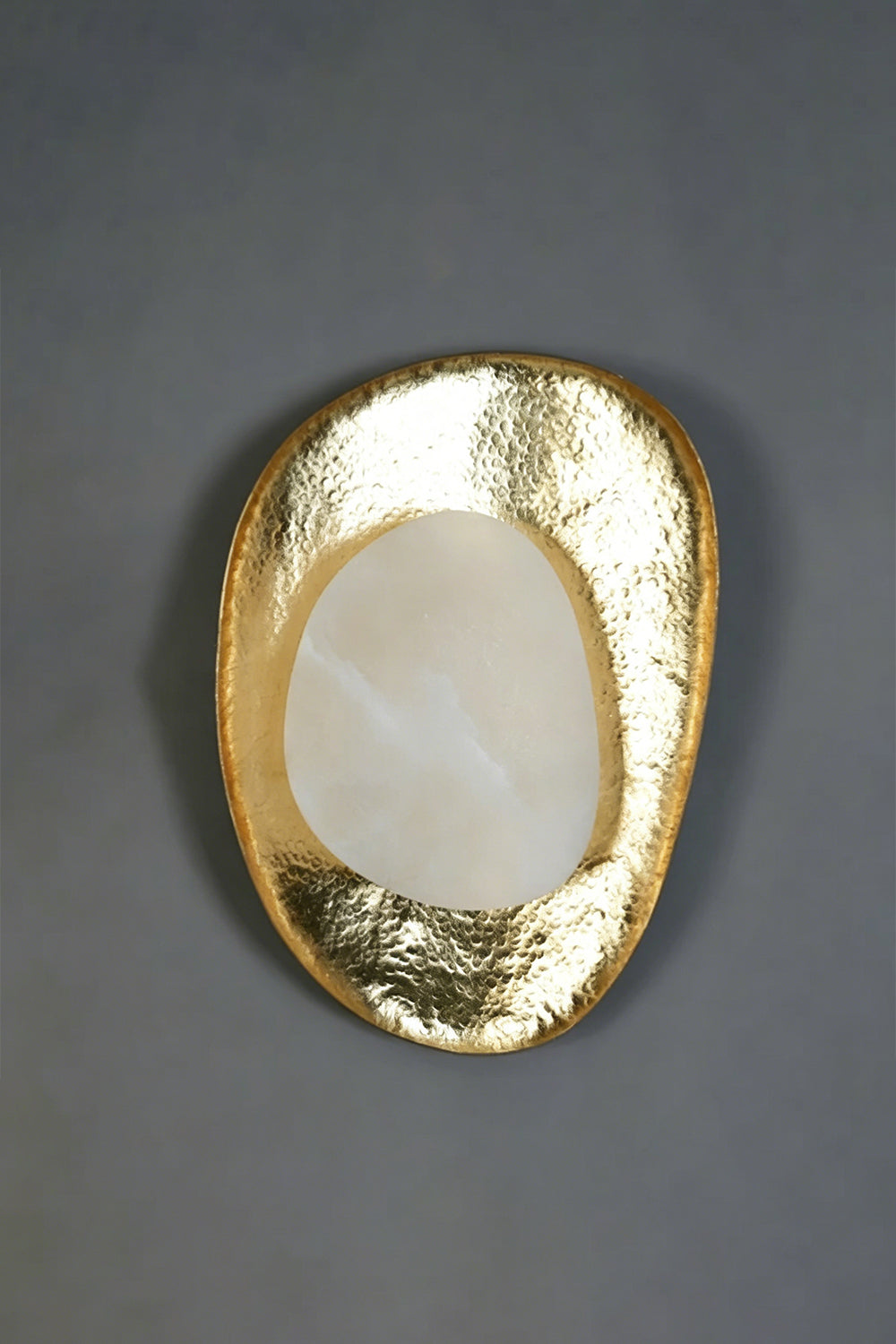 Caeliform Aurelia Alabaster Wall Lamp | Alabaster, Brass | The lamp mounted on a dark grey, textured feature wall for a dramatic, moody contrast | Isolated product shot | vexa lamps