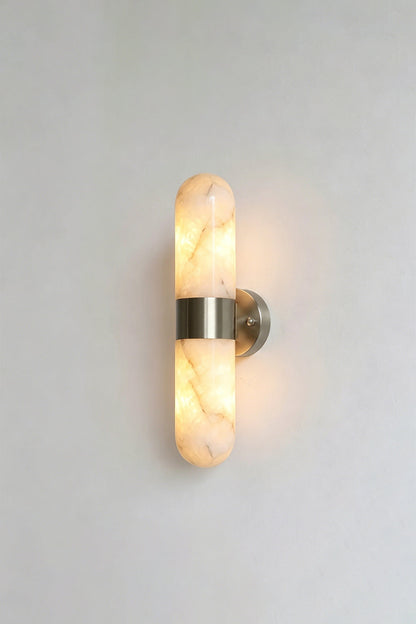 Calla Alabaster Capsule Wall Sconce | Alabaster, Metal | Another lit studio view of the polished chrome or silver nickel variant casting an elegant glow | vexa lamps
