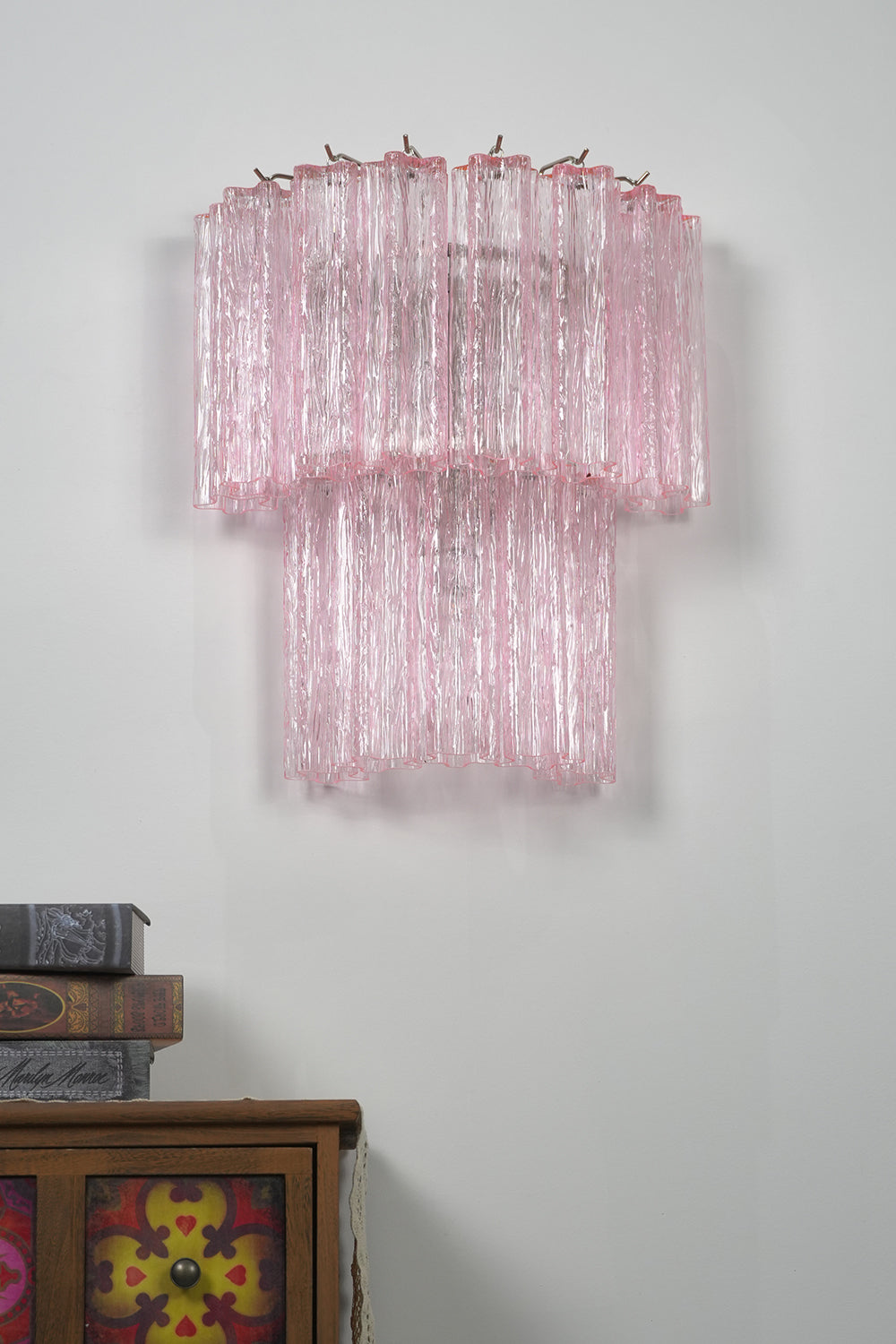 Cascading Prism Pink Glass Wall Light | Glass, Metal | Front view of the unlit pink glass lamp showing its texture against a grey wall | Isolated shot | vexa lamps Cascading Prism