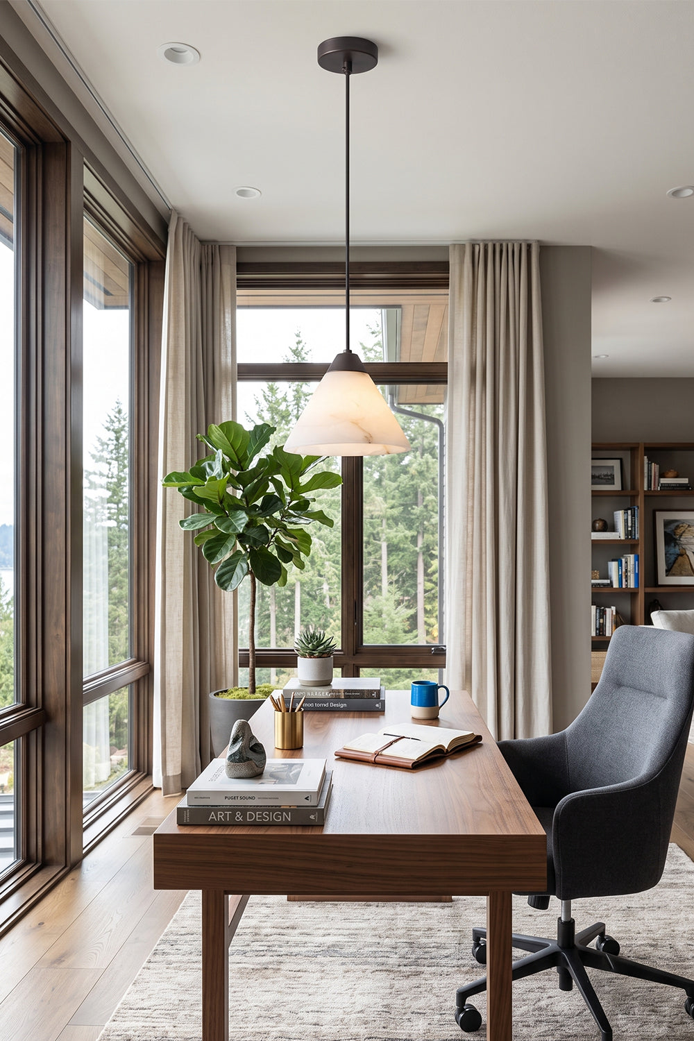 Caspian Conical Alabaster Pendant Light | Natural Alabaster and Brass | Positioned over an elegant wooden desk with a black leather chair looking out a scenic window | vexa lamps