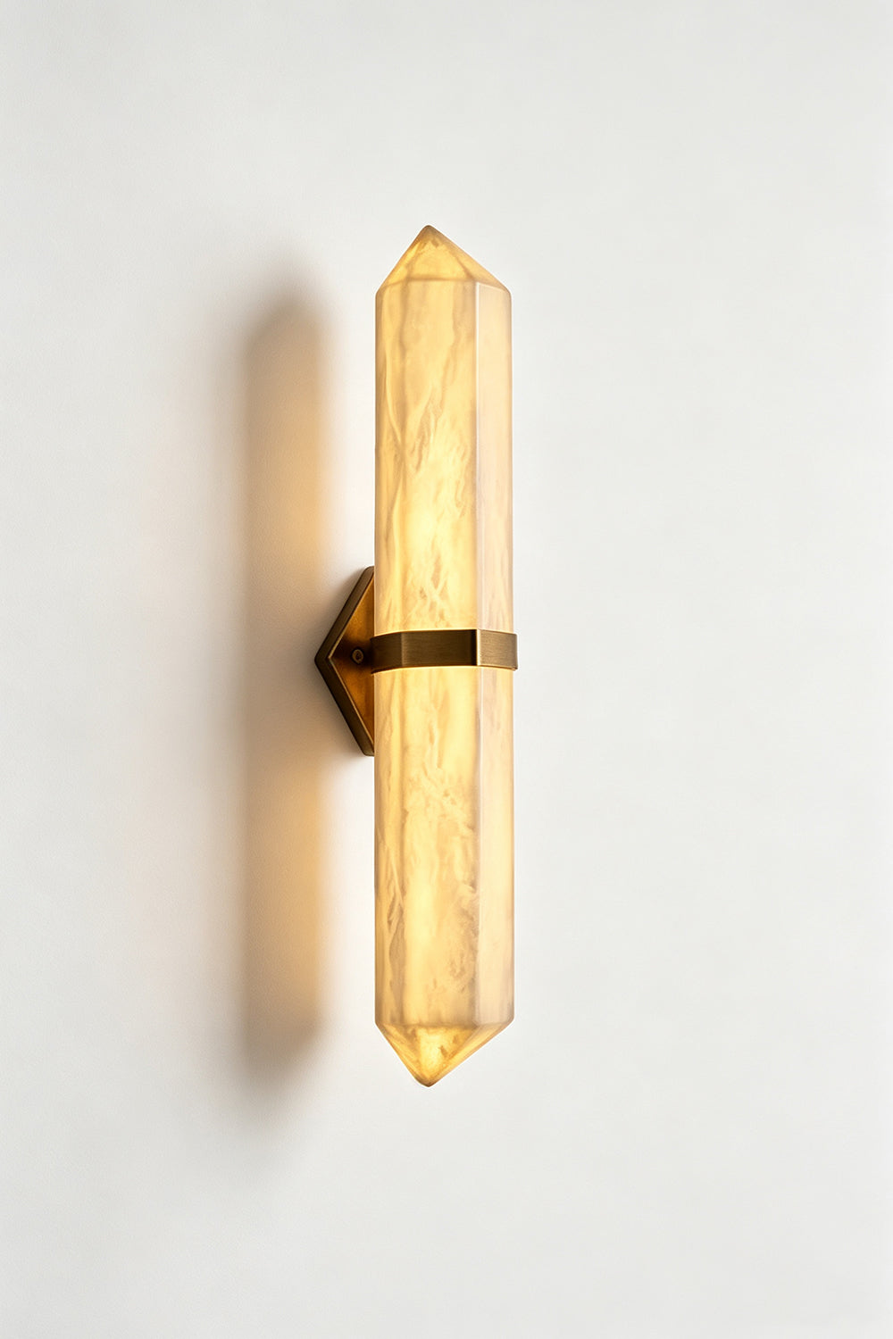 Cassian Faceted Alabaster Wall Sconce featuring a double-pointed alabaster column with brass-toned bracket.
