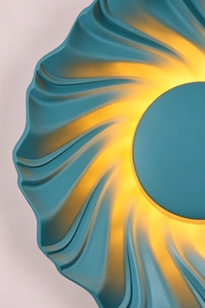 Centripetal Solstice Metal Wall Lamp | Metal, Resin | Close-up of the blue textured lamp, highlighting the vibrant blue concentric ripples and warm glowing light | vexa lamps