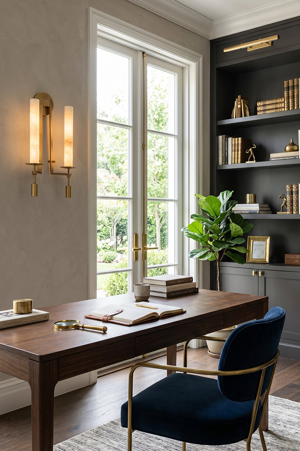 Chantal Twin Alabaster Wall Sconce | Alabaster, Brass | Providing sophisticated accent lighting in a home library office next to a dark wood executive desk and a plush navy blue chair | vexa lamps