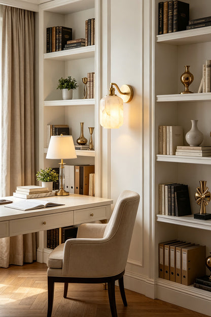 Cordelia Scalloped Alabaster Wall Sconce | Natural Alabaster and Brushed Brass | Styled in a sophisticated home office study next to white built-in library bookshelves and a desk | vexa lamps