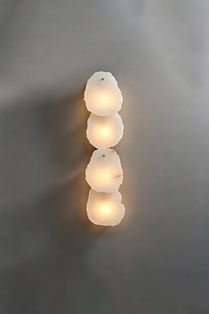 Corin Alabaster Wall Sconce featuring three stacked alabaster columns glowing softly.