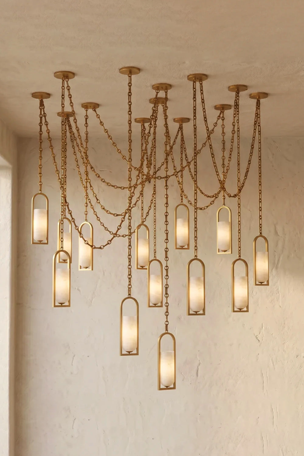 Cressida Alabaster Melange Chain Chandelier hanging from the Cressida Alabaster Melange Chain Chandelier hanging from the ceiling in an upscale modern interior.ceiling in an upscale modern interior.