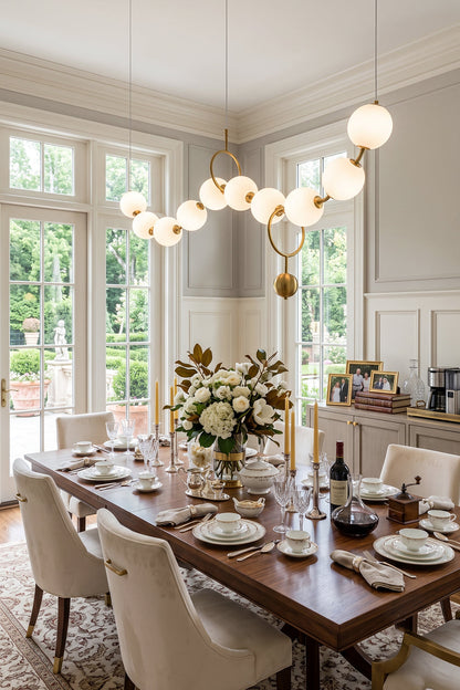 Delphine Pearl Strand Chandelier illuminating a dining table with floral centerpiece and elegant table settings.