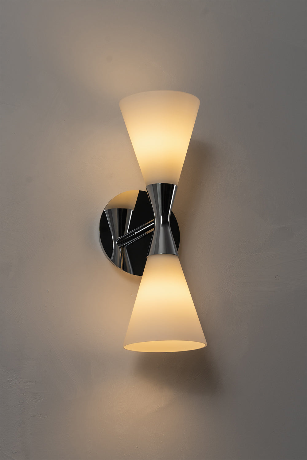 Diabolo Symmetry Glass Wall Sconce featuring dual conical glass shades and a sleek brushed brass design.