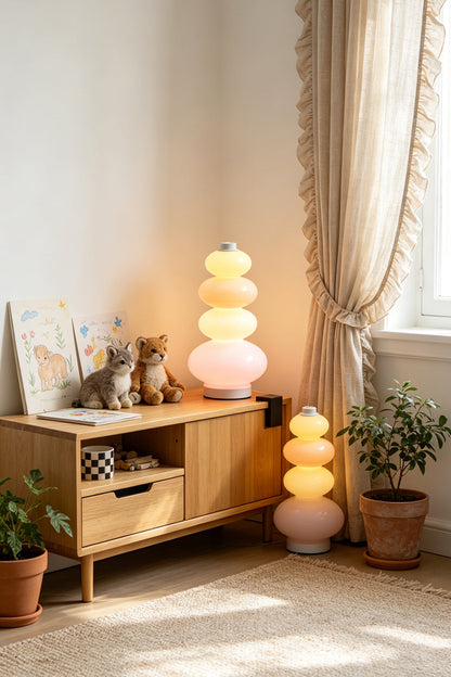 Dolce Stacked Pastel Glass Table Lamp | Glass, Metal | Displayed on a rustic wooden credenza next to a sunlit window with flowing lace curtains | vexa lamps
