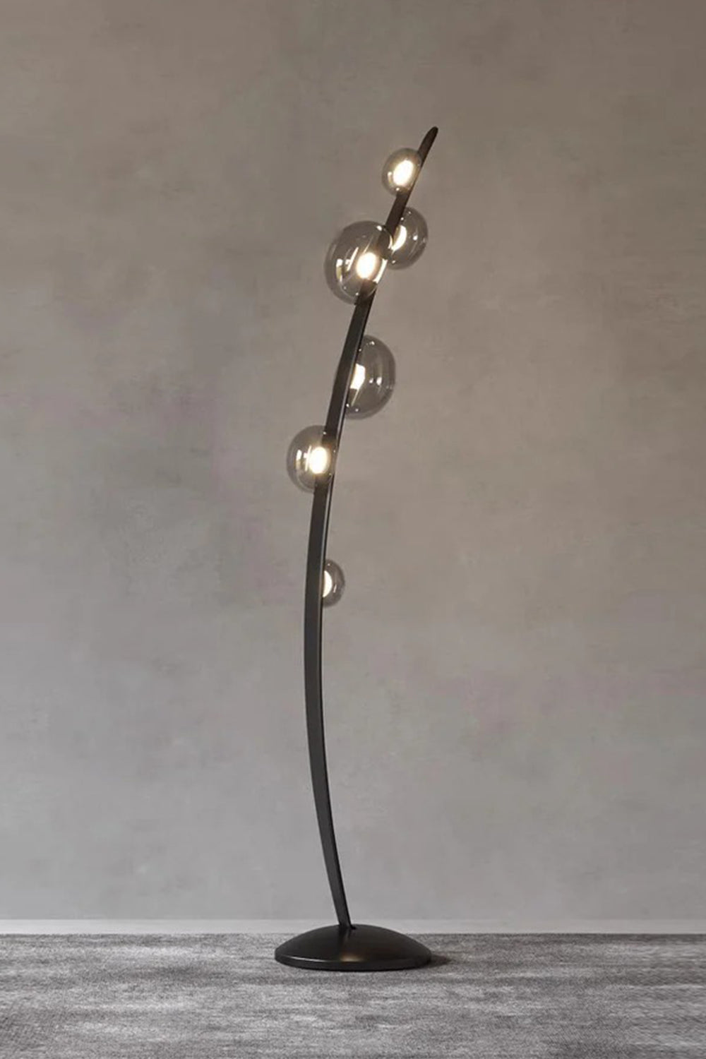Drosia Dewdrop Floor Lamp | Glass, Metal | Studio view of the unlit organic black floor fixture showcasing its sculptural curved form and clear glass spheres against a grey backdrop | vexa lamps