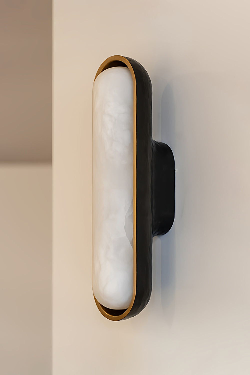 Elara Capsule Alabaster Wall Sconce showcasing a unique design with alabaster diffuser and matte black casing.
