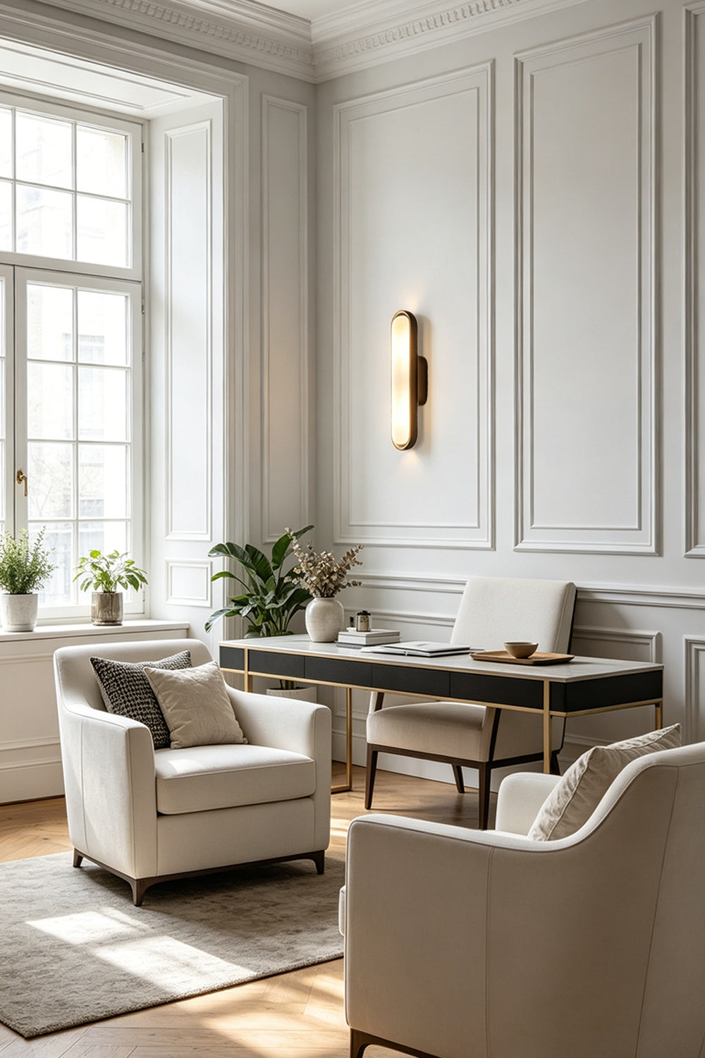 Elara Capsule Alabaster Wall Sconce illuminating a modern minimalist office space with neutral tones.