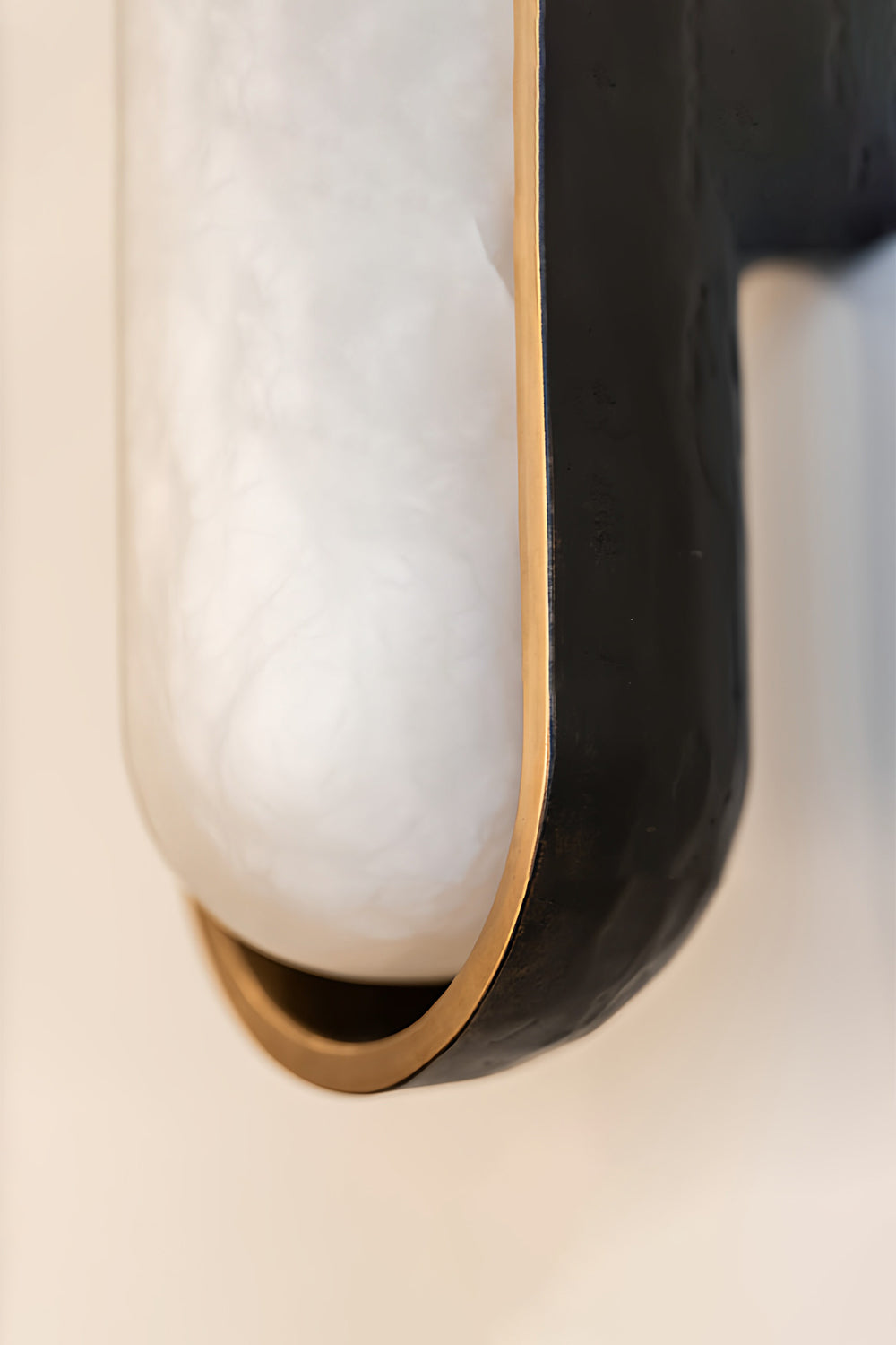Close-up of Elara Capsule Alabaster Wall Sconce showcasing alabaster diffuser and matte black casing.