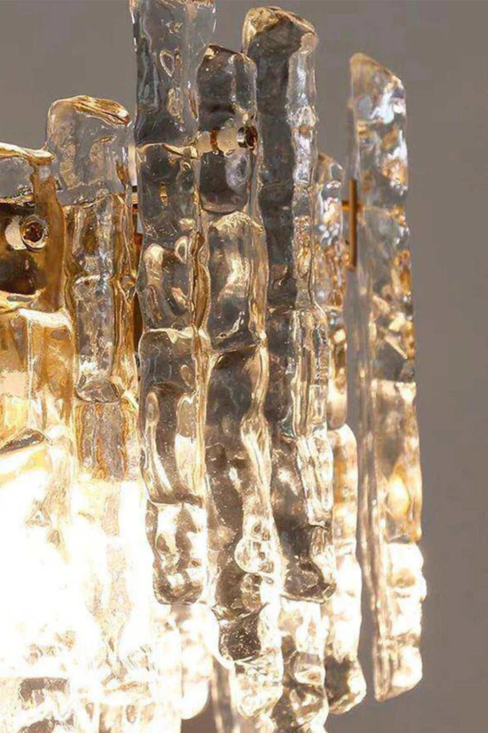 Elara Textured Cast Glass Wall Lamp | Textured Cast Glass, Polished Brass | Extreme close-up detail macro shot focusing on the rough, flowing texture and multi-faceted patterns of the unique, artisanal cast glass panels | vexa lamps