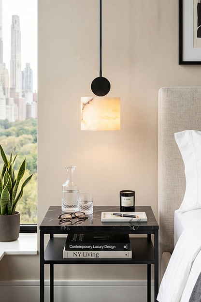 Elian Minimalist Alabaster Pendant Light illuminating a modern bedroom with stylish decor.