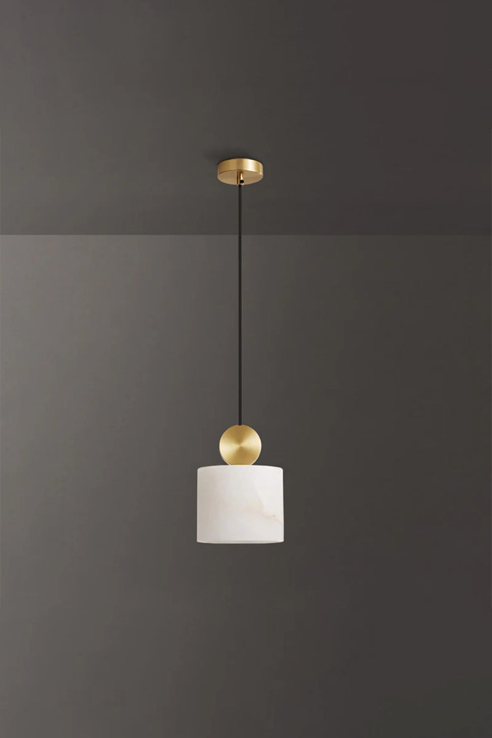 Elian Minimalist Alabaster Pendant Light hanging from the ceiling against a dark background with a gold accent.