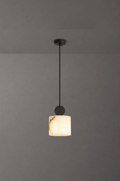 Elian Minimalist Alabaster Pendant Light hanging in a contemporary space with a sleek black cord and ceiling mount.