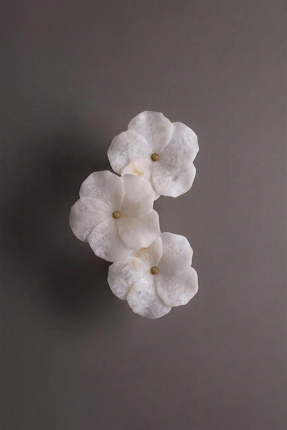 Elowen Alabaster Blossom Wall Light | Studio Profile View | Angled profile studio view of the unlit multi-flower sculptural stone wall fixture against a plain background wall | vexa lamps