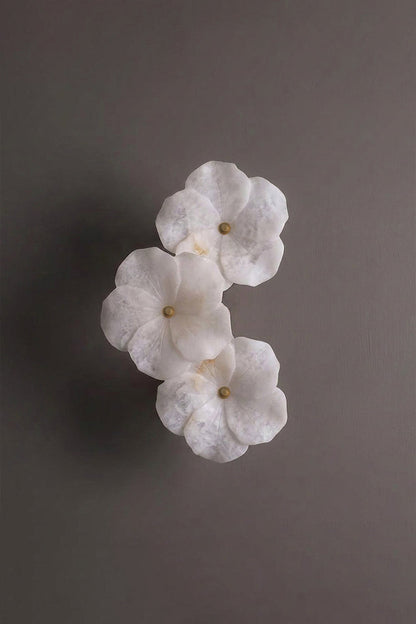 Elowen Alabaster Blossom Wall Light | Studio Profile View | Angled profile studio view of the unlit multi-flower sculptural stone wall fixture against a plain background wall | vexa lamps