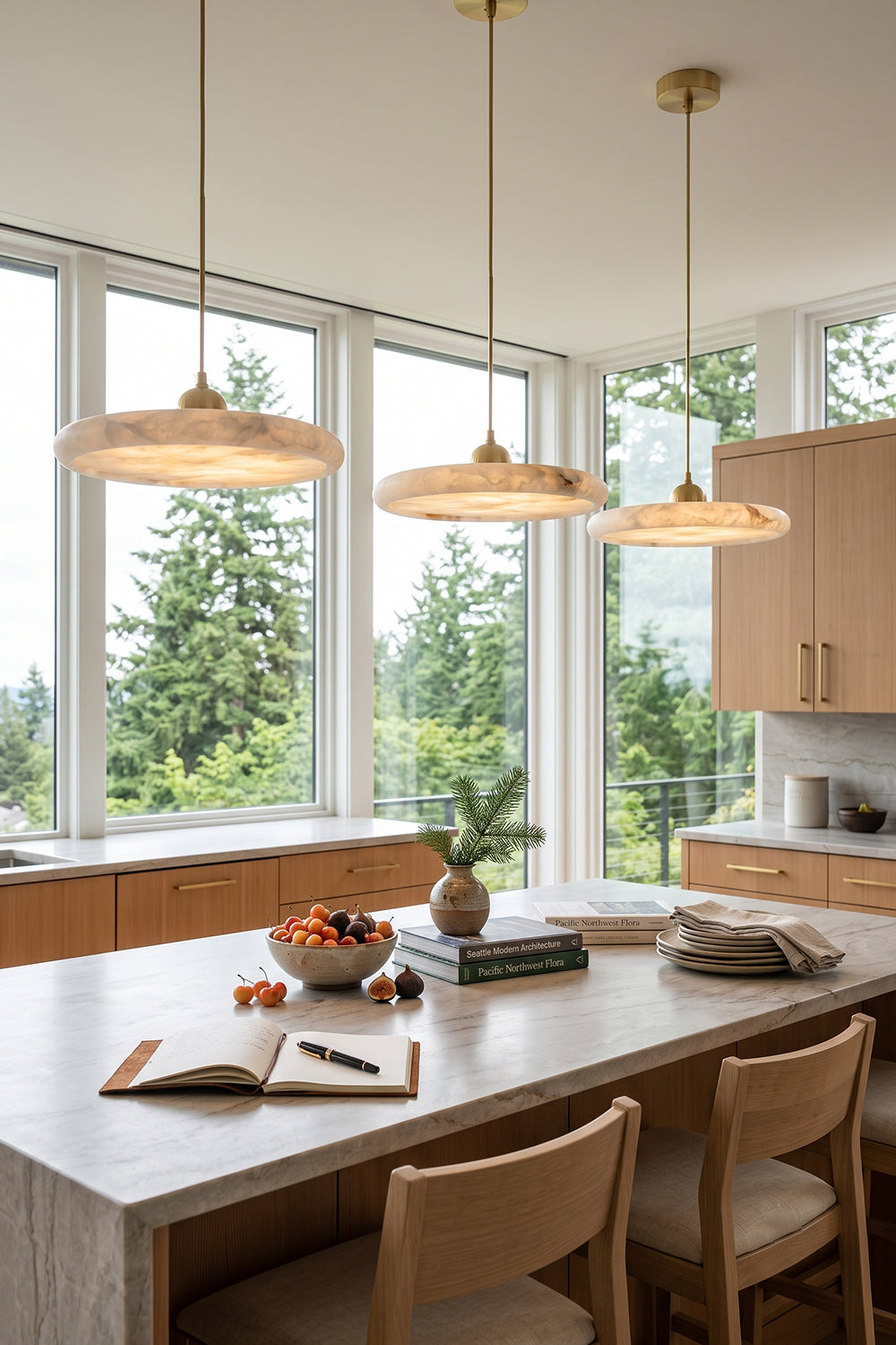 Elowen Alabaster Disc Pendant Light| Natural Alabaster and Brass | Suspended in a row over an indoor dining table against a wall of bright floor-to-ceiling windows | vexa lamps