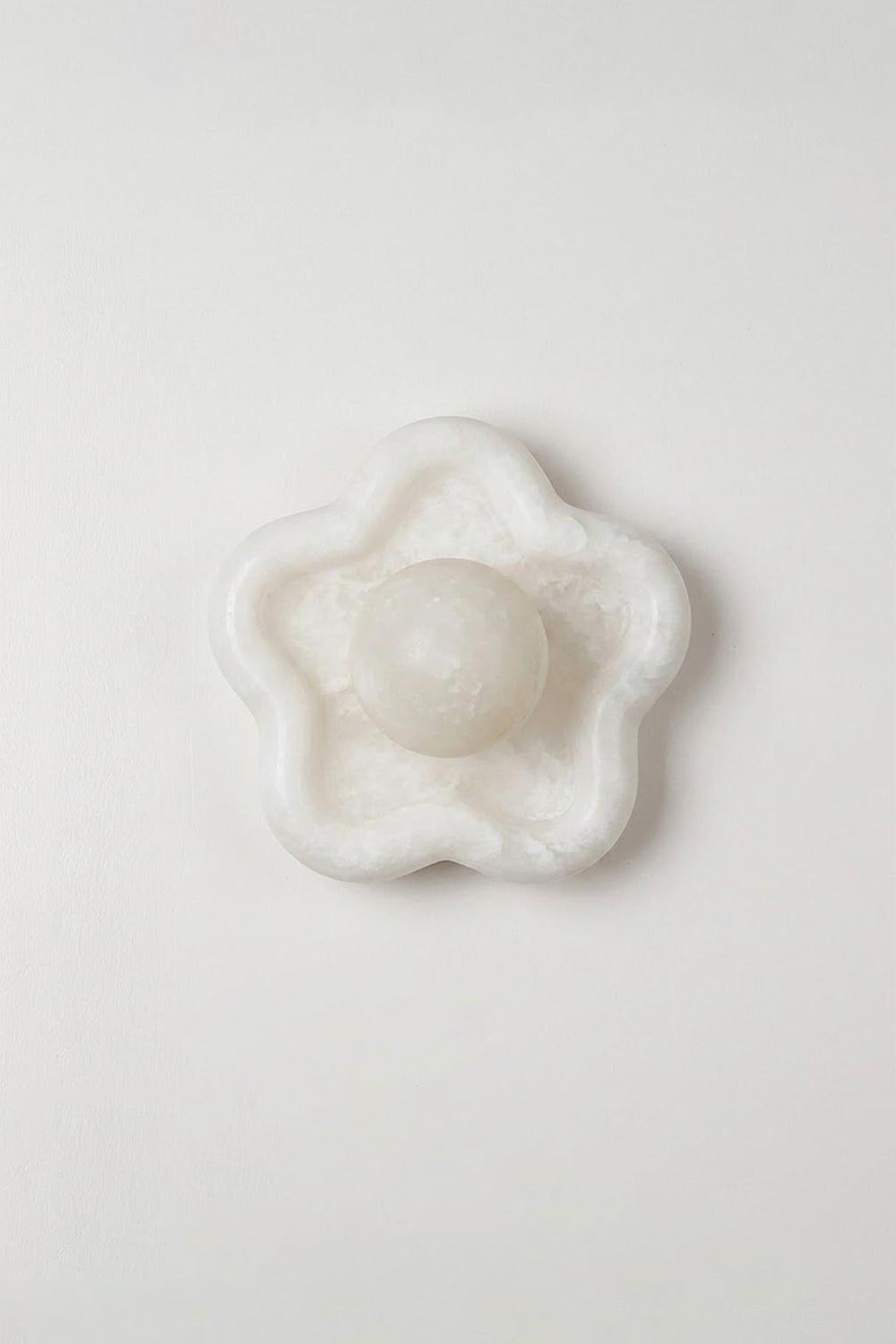 Elowen Petal Alabaster Wall Sconce | Natural Alabaster | Studio product presentation showing the unlit floral stone fixture hanging on a plain light wall | vexa lamps