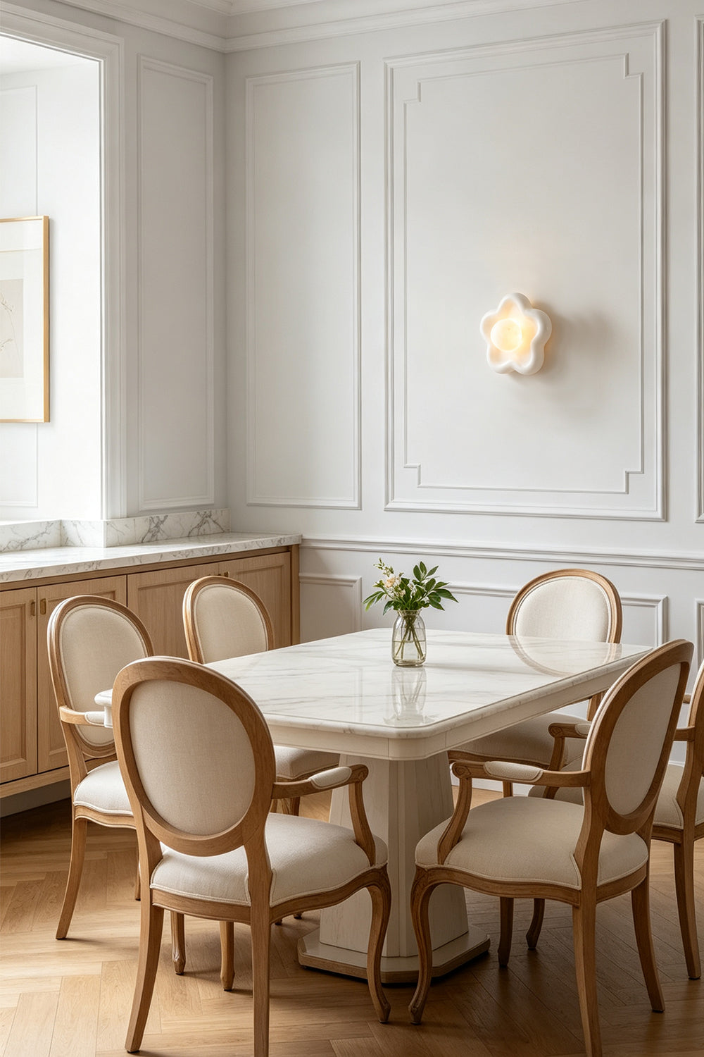 Elowen Petal Alabaster Wall Sconce | Natural Alabaster | Illuminating a minimalist white dining room space above a clean dining table and matching chairs | vexa lamps